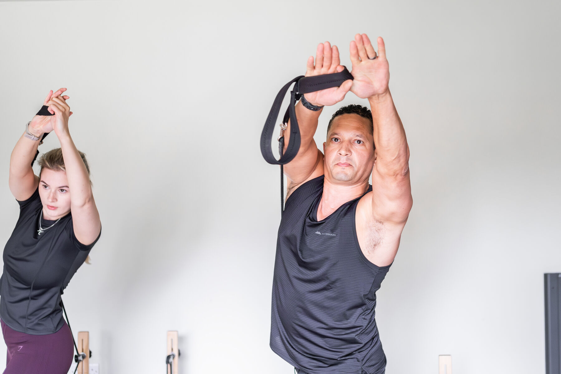 Two clients working their arms with resistance straps